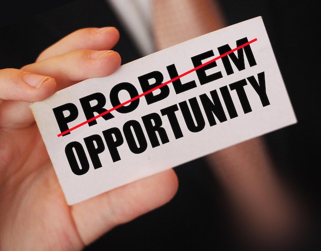 Empresário segurando um cartão com a palavra problema eliminado e problema de oportunidade se transforma em conceito de gerenciamento de crises de negócios de oportunidade