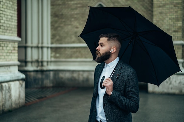 Empresário segurando um guarda-chuva preto