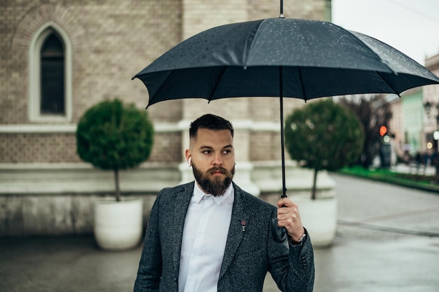 Foto empresário segurando um guarda-chuva preto