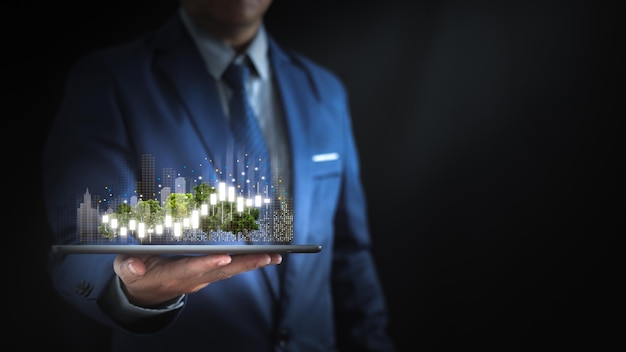 Empresário segurando um tablet com gráficos e cidades virtuais conceito de gestão econômica urbana liderança confiável