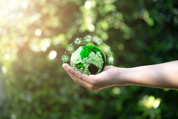 Foto empresário segurando uma bola de papel verde com mapa mundial e ícone ambiental, como redução de carbono, reciclagem de fábrica verde e célula solar para crédito de emissão zero de carbono para evitar o aquecimento global