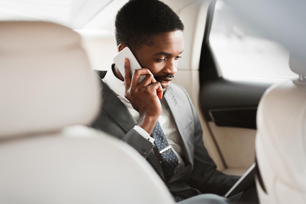 Empresário sempre disponível tendo conversa de negócios no carro