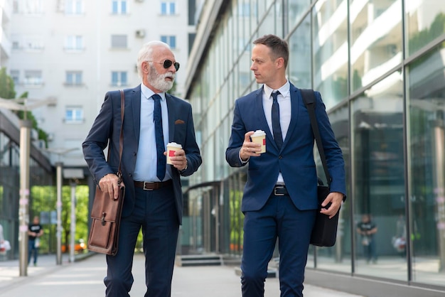 Empresario senior discutiendo algo positivo con su joven colega