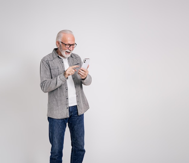 Empresário sênior entusiasmado lendo boas notícias no smartphone e rindo em fundo branco