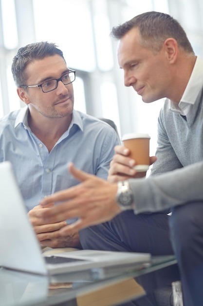 Empresario senior portátil y colega discutiendo una propuesta o idea de acuerdo en la oficina Gente de negocios hablando de estrategia o planeando estrategia de mercado o publicidad en conversación en el lugar de trabajo