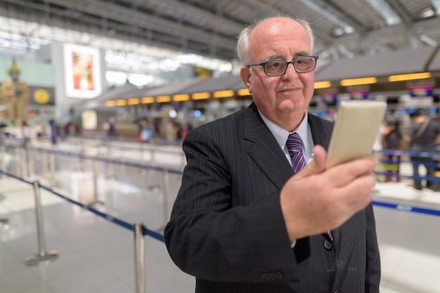 Empresario senior con sobrepeso descansando alrededor del aeropuerto de Ban