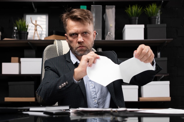 Empresário sentado à mesa do computador e documento de lágrimas