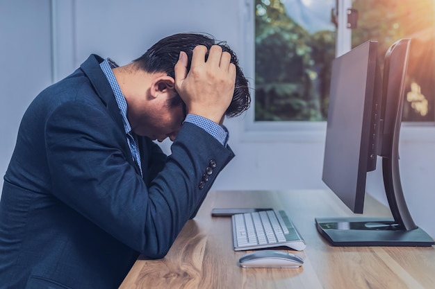 Empresário sentado estressado na frente de um computador