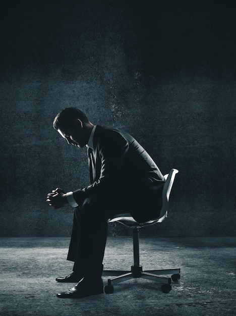 Foto empresário sentado na cadeira na sala de concreto