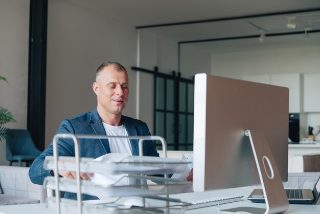 Empresario sentado en una oficina trabajando con una computadora portátil. Retrato de hombre de negocios.