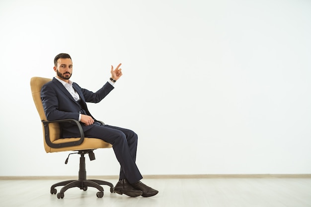 El empresario sentado en una silla de oficina y gesticulando