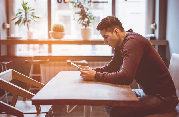 Foto el empresario sentado con una tableta en el café