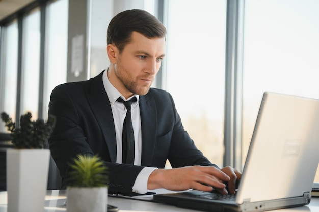 Foto empresário sério focado em terno pensando lendo notícias on-line ou resolvendo problemas de negócios trabalhando no laptop olhando para a tela preocupado executivo confuso gerenciando riscos do mercado de ações usando computador