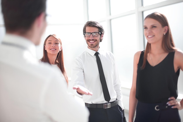 Empresario sonriente da la bienvenida a su pareja con un apretón de manos