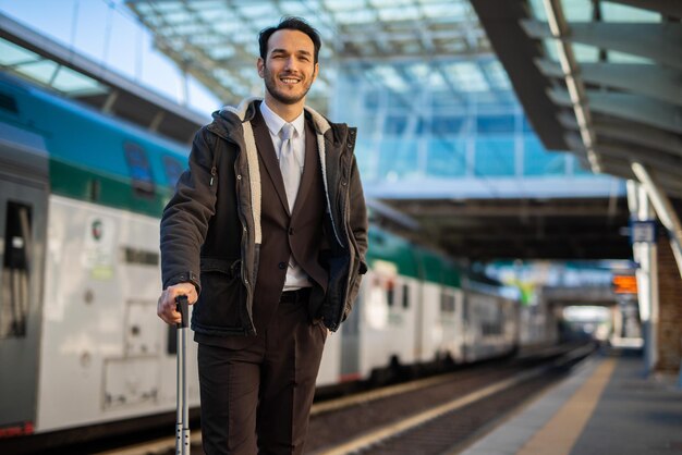 Empresario sonriente en la estación de tren