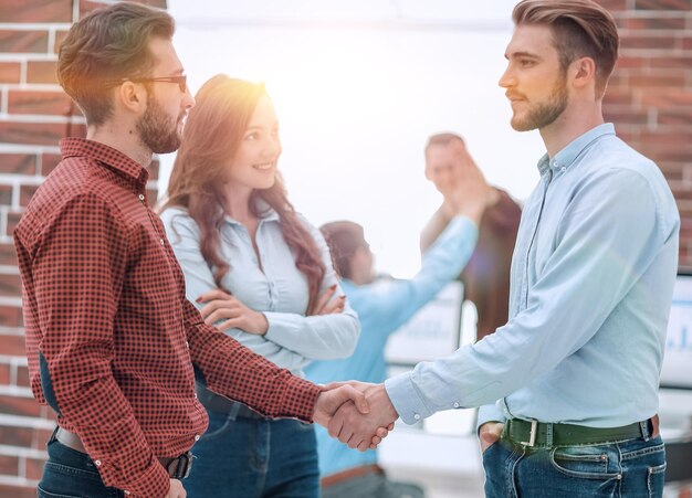 Foto empresario sonriente estrechando la mano con un colega en el cargo.