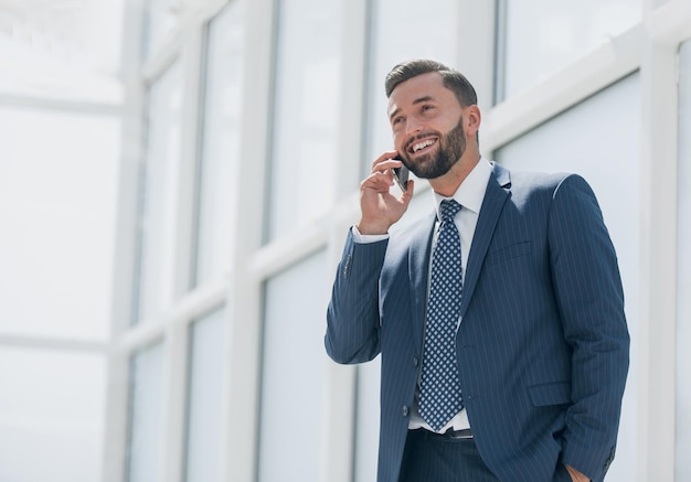 Empresario sonriente hablando por un teléfono móvilfoto con espacio de texto