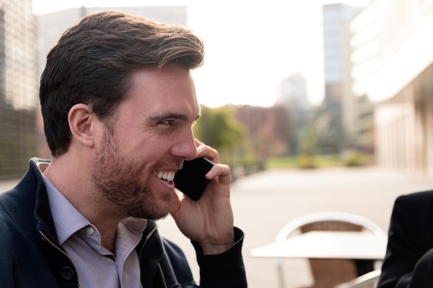 Empresario sonriente hablando por teléfono