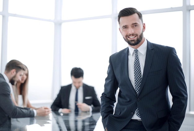 Empresario sonriente de pie en una foto de oficina brillante con espacio de copia