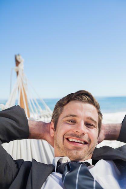 Empresario sonriente relajante en hamaca