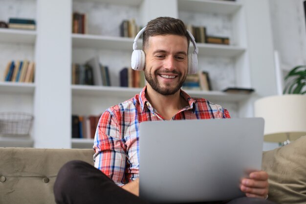 Empresario sonriente saludando a sus colegas en videoconferencia y negociando a distancia desde casa.