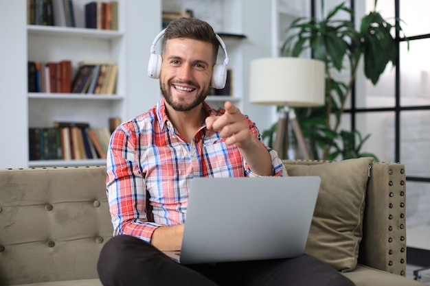 Empresario sonriente saludando a sus colegas en videoconferencia y negociando a distancia desde casa.