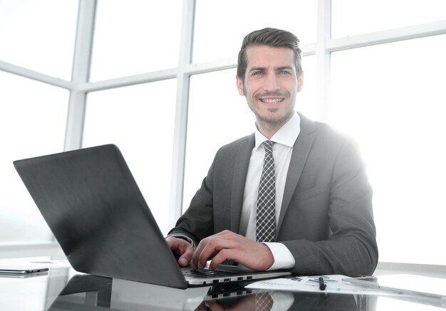 Empresario sonriente sentado en su escritorio personas y tecnología