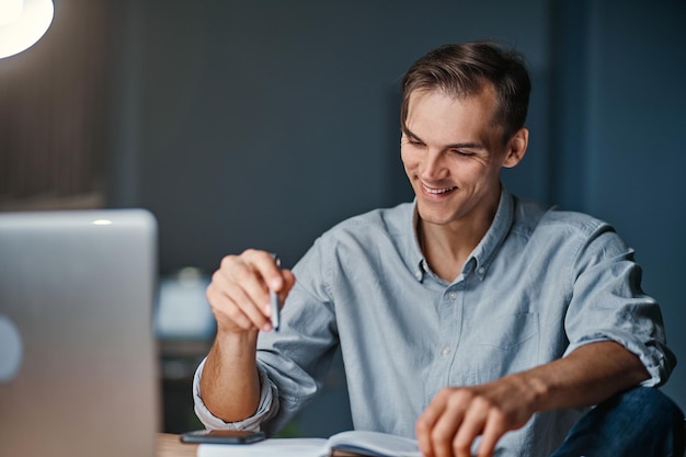 Empresario sonriente trabajando en un nuevo proyecto por la noche