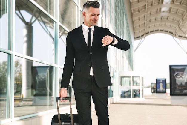 Empresario sonriente vestido con traje caminando