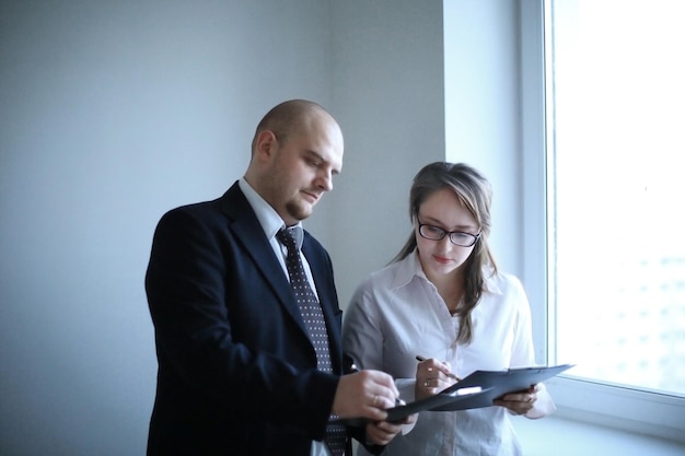 Foto empresario sorprendido y asistente discutiendo documentos comerciales