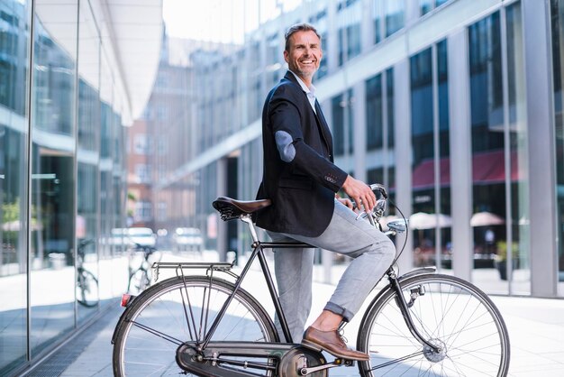 Empresário sorridente em bicicleta na cidade