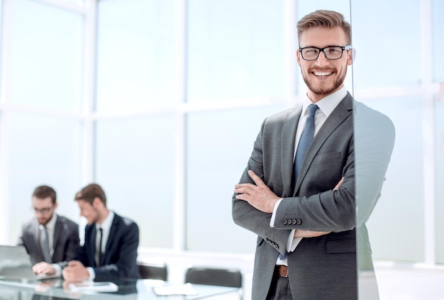 Empresário sorridente no fundo do escritório desfocado