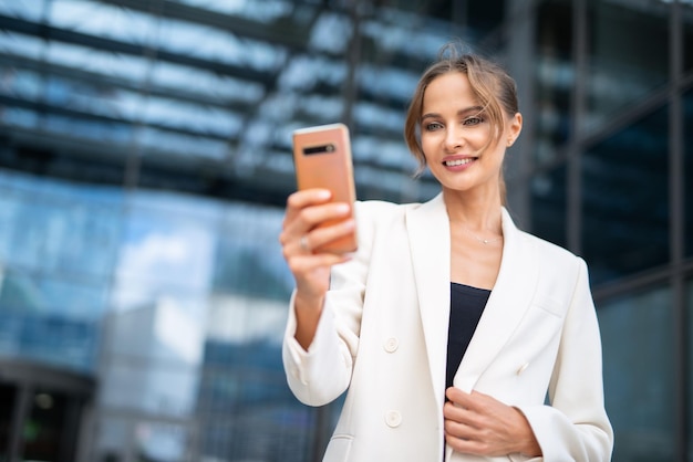 Empresário sorridente tirando uma selfie com seu smartphone