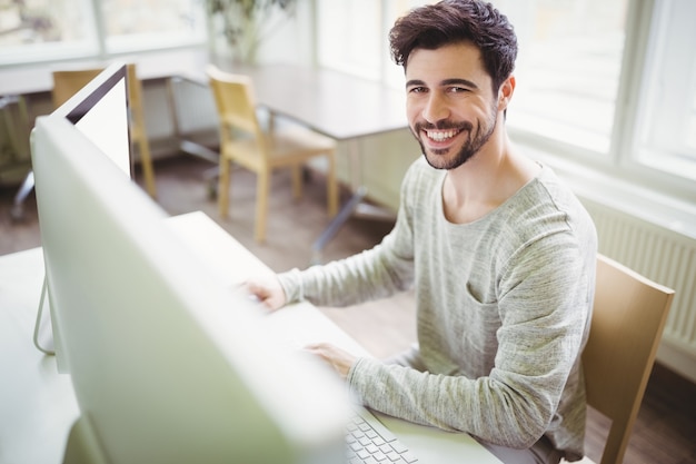 Foto empresário sorridente, trabalhando na mesa no escritório