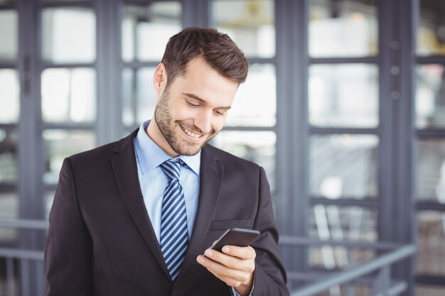 Empresário sorrindo enquanto olha para o telefone móvel