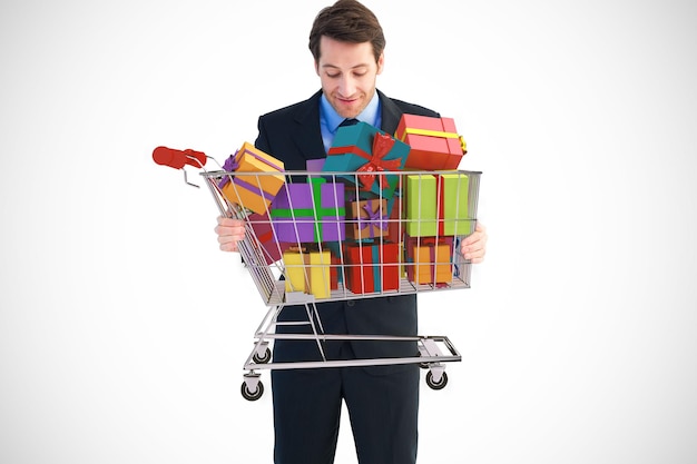 Empresario sosteniendo algo con las manos contra el carro lleno de regalos