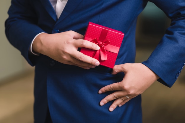 Empresario sosteniendo la caja de regalo roja