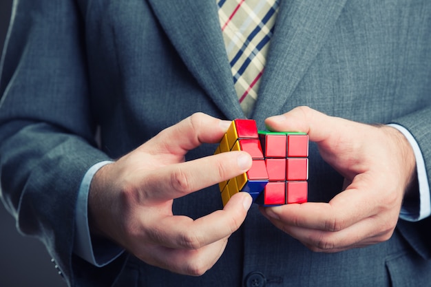 Empresario sosteniendo el cubo de rubik en sus manos