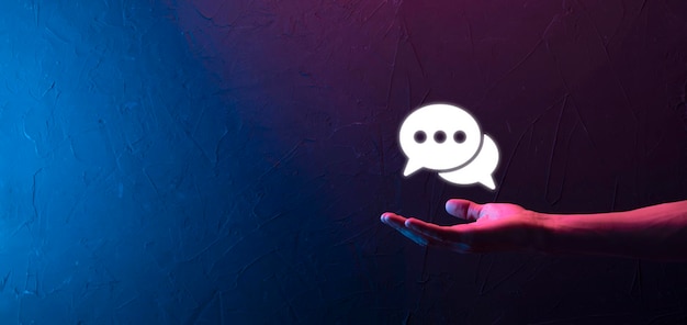 Empresario sosteniendo un icono de mensaje, señal de notificación de conversación de burbujas en sus manos. Icono de chat, icono de sms, icono de comentarios, bocadillos.