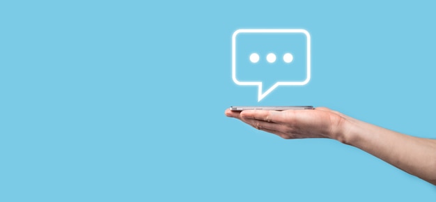 Empresario sosteniendo un icono de mensaje, señal de notificación de conversación de burbujas en sus manos. Icono de chat, icono de sms, icono de comentarios, burbujas de voz