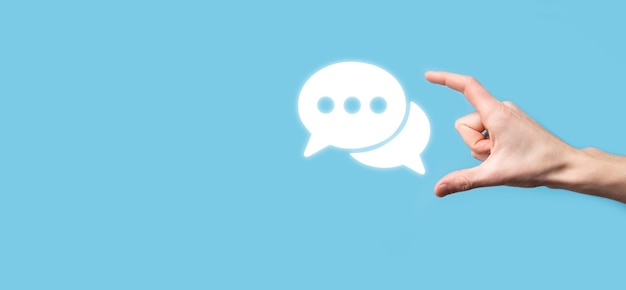 Empresario sosteniendo un icono de mensaje, señal de notificación de conversación de burbujas en sus manos. Icono de chat, icono de sms, icono de comentarios, burbujas de voz