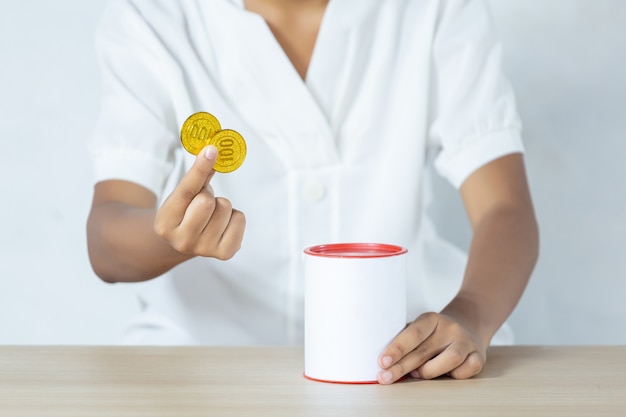 Empresario sosteniendo monedas de oro poniendo en banco de monedas. concepto de ahorro de dinero para la contabilidad financiera