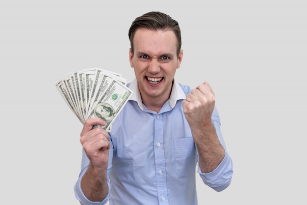 Empresario sosteniendo muchos billetes de dinero aislado sobre fondo de color gris