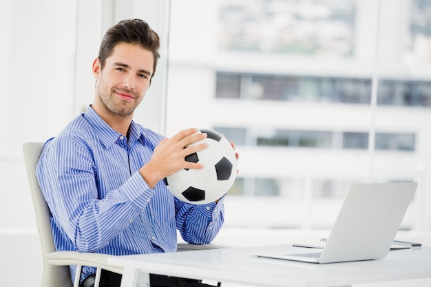 Empresario sosteniendo una pelota de fútbol