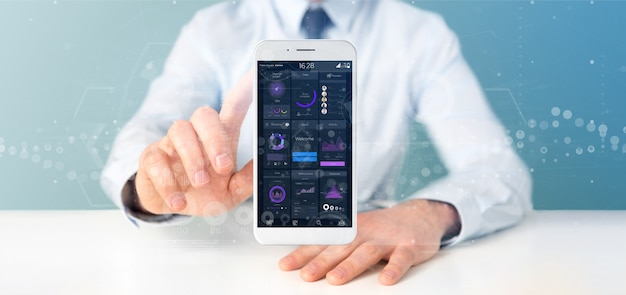 Empresario sosteniendo Smartphone con datos de la interfaz de usuario en la pantalla aislada
