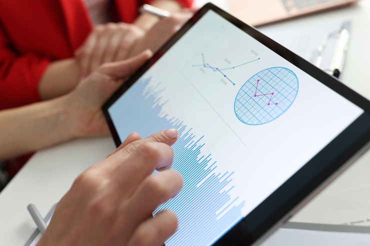 Foto empresario sosteniendo tableta con gráficos y diagramas en sus manos en el lugar de trabajo