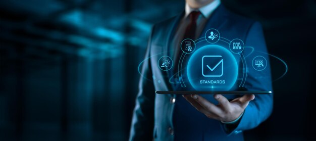 Empresario sosteniendo una tableta con iconos de estándares en la pantalla concepto de gestión de calidad