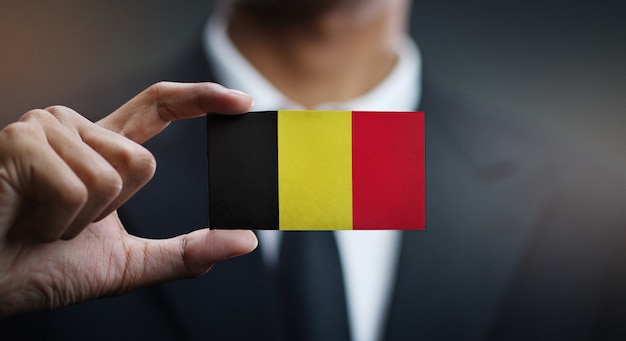 Empresario sosteniendo la tarjeta de bandera de Bélgica