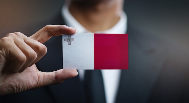 Empresario sosteniendo la tarjeta de bandera de malta