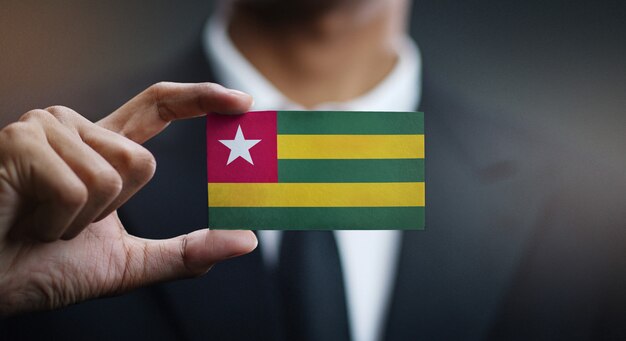 Foto empresario sosteniendo la tarjeta de bandera de togo